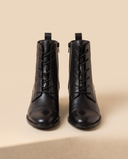 Boots PRODIGIEUSE noires debout sur fond beige