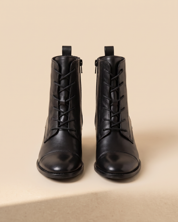 Boots PRODIGIEUSE noires debout sur fond beige