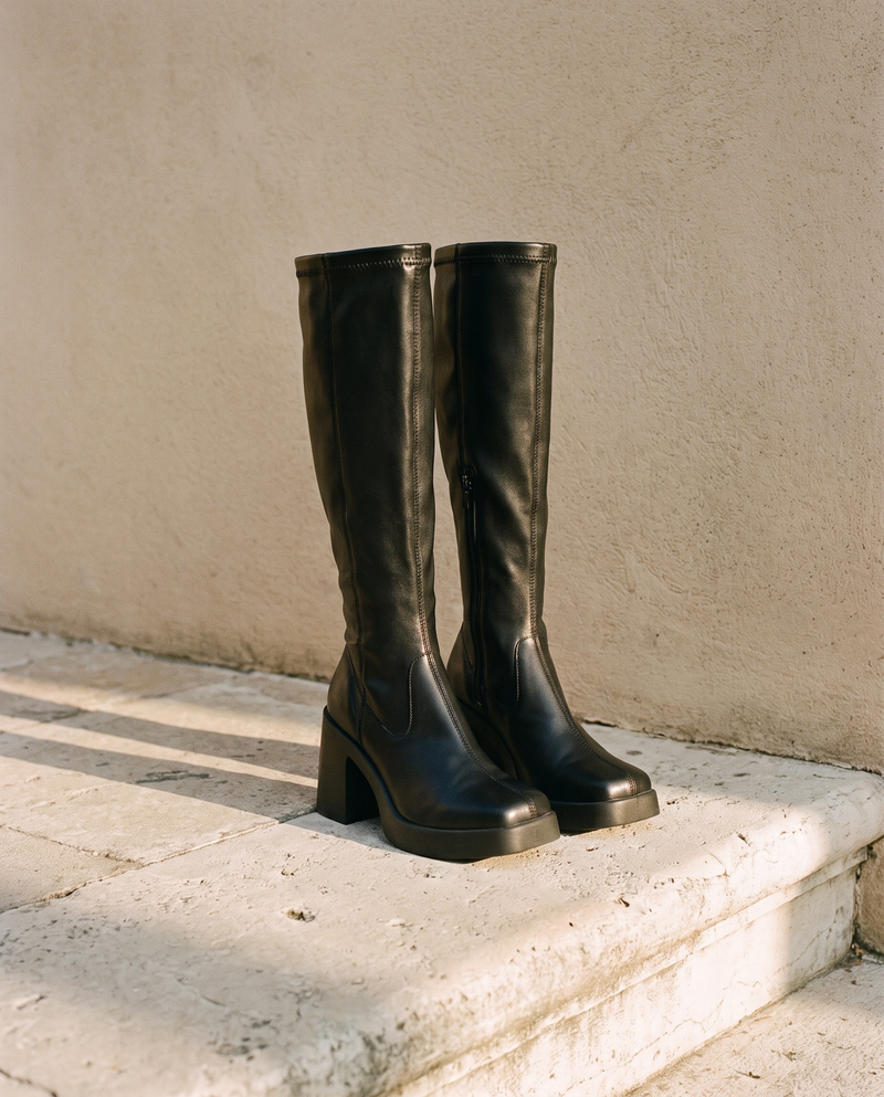Paire de bottes RATA noires posée sur une marche en pierre — André