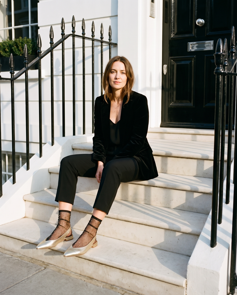 Slingback ROSEE dorée portée, femme assise sur le perron d'une maison londonienne