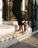 Slingback ROSEE dorée portée, gros plan, un pied posé sur la marche d'une maison londonienne