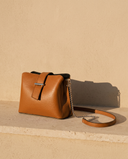 Sac SÉRAPHINE cognac Maison André sur une marche en pierre