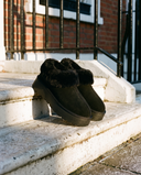Boots fourrées SNOWFLAKE noires posées sur le perron d'une maison londonienne