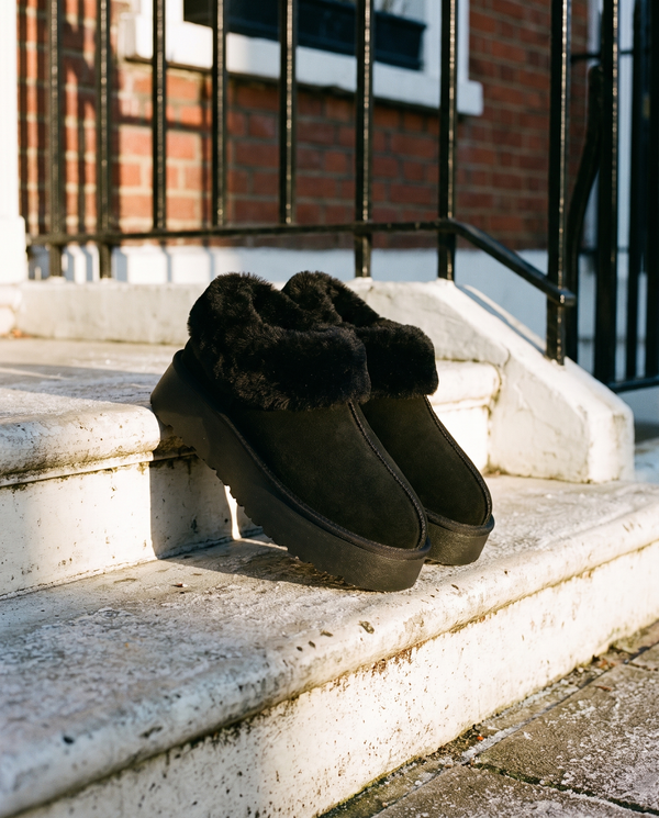 Boots fourrées SNOWFLAKE noires posées sur le perron d'une maison londonienne