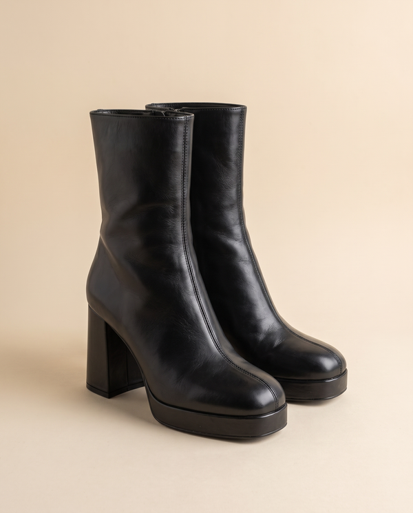 Boots SONATA noires debout sur fond beige