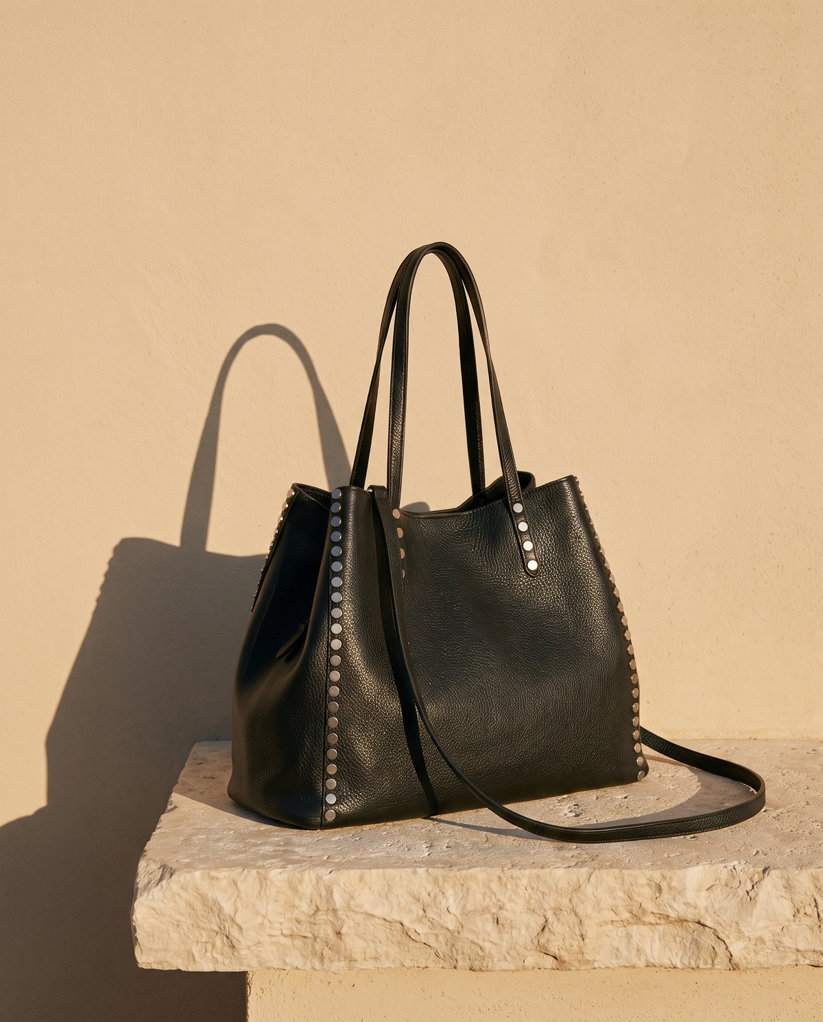 Sac SONIA noir Maison André sur une marche en pierre
