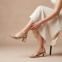 André Tarsila OR gold metallic strappy block heel sandals with clear straps and adjustable ankle buckle.