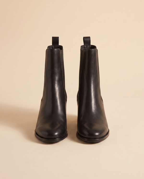 Boots TERESIA noires debout sur fond beige