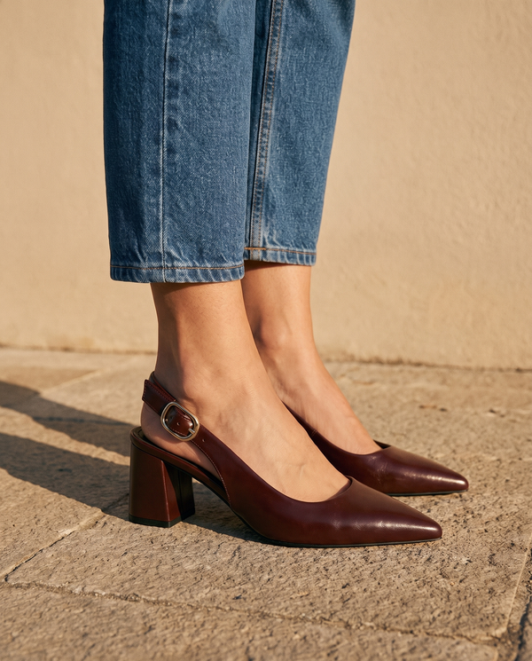 Gros plan sur les chevilles portant les slingbacks THAÏS bordeaux — A by André
