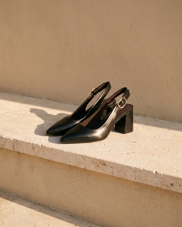 Paire de slingbacks THAÏS noirs posée sur une marche en pierre — A by André