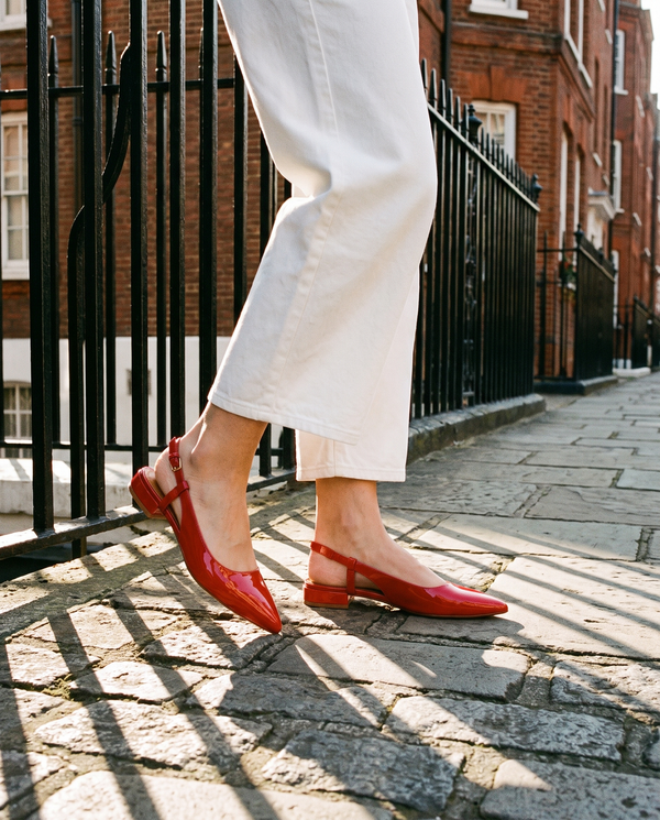 Slingback THALASSA rouge portée, gros plan, sur les pavés d'une rue londonienne