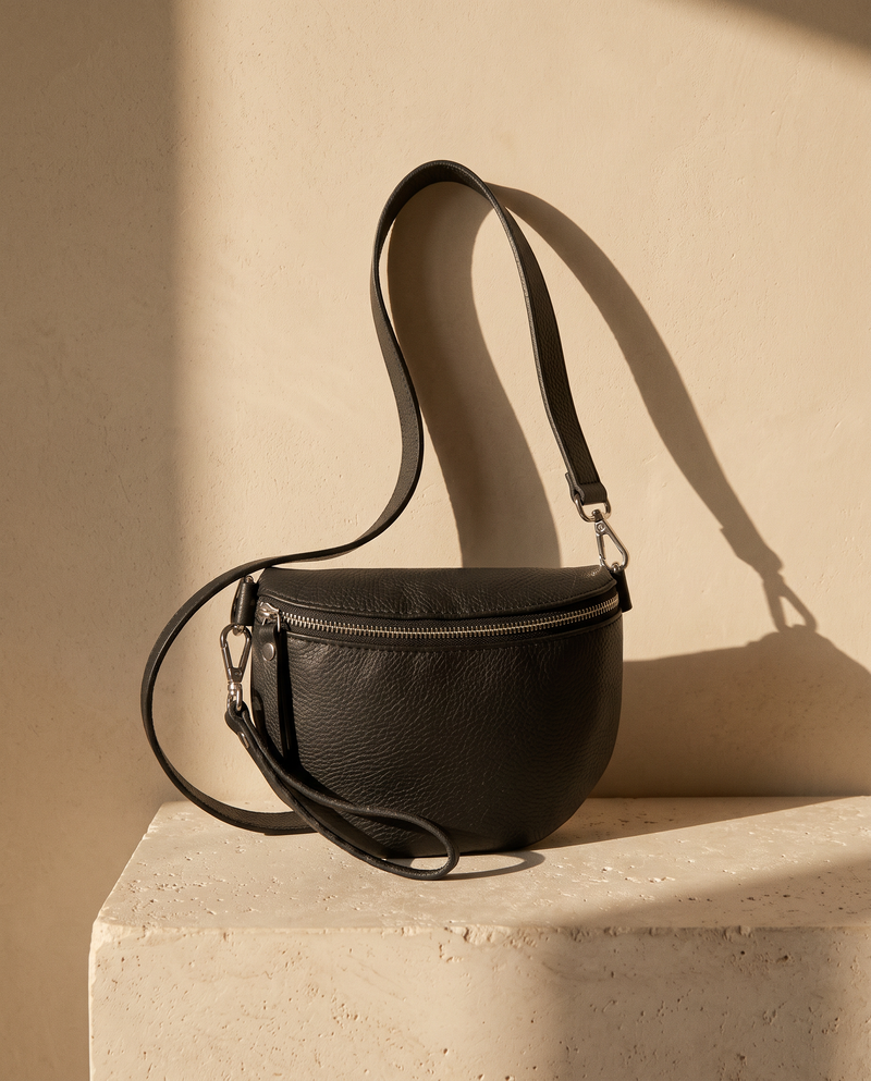 Sac THÉA noir Maison André sur une marche en pierre