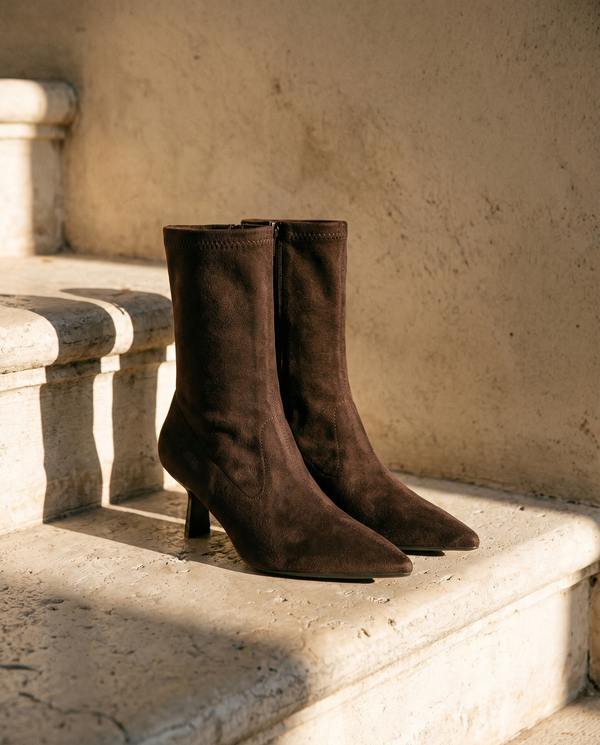 Paire de boots VANINA marron posée sur une marche en pierre — A by André
