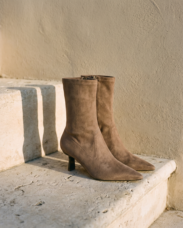 Paire de boots VANINA taupe posée sur une marche en pierre — A by André