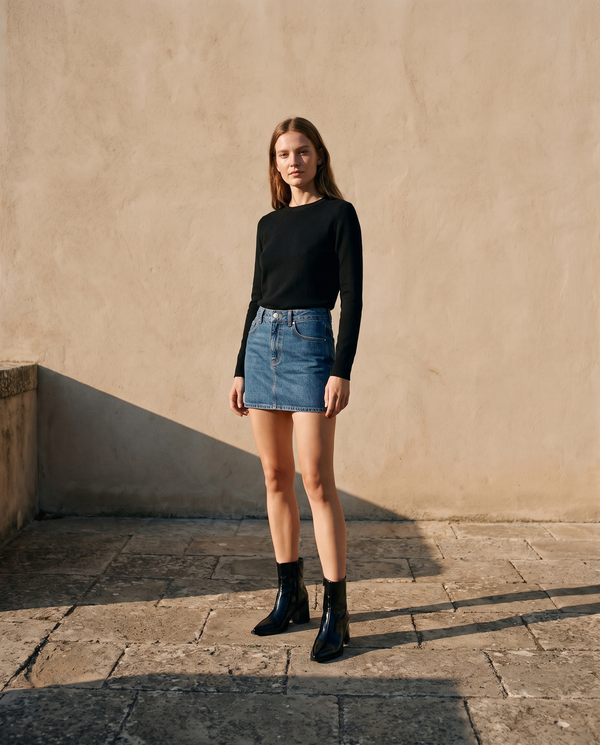 Boots VICTORIA noires portées avec une jupe en jean sur une terrasse en pierre — A by André